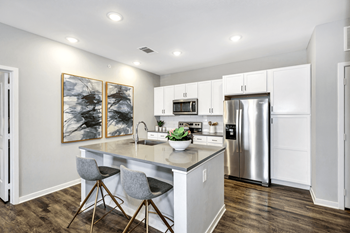 a kitchen with white cabinets and stainless steel appliances